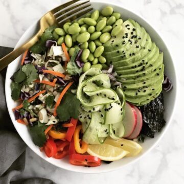 A buddha bowl with a fork and napkin.