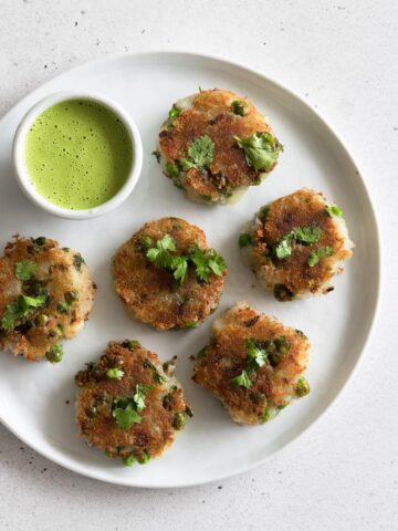 A plate of aloo tikki with a bowl of chutney