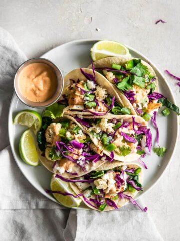 A plate of cauliflower tacos with a sauce