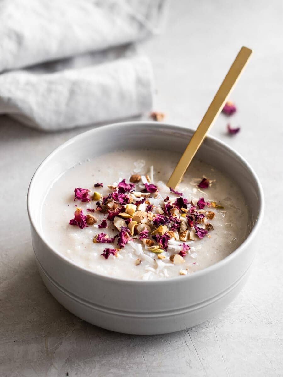 A bowl of Kheer, garnished with dried rose petals.