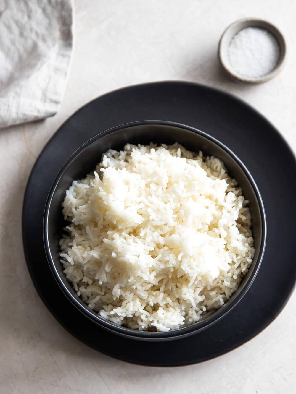A bowl of Instant Pot Basmati Rice with a bowl of salt next to it.