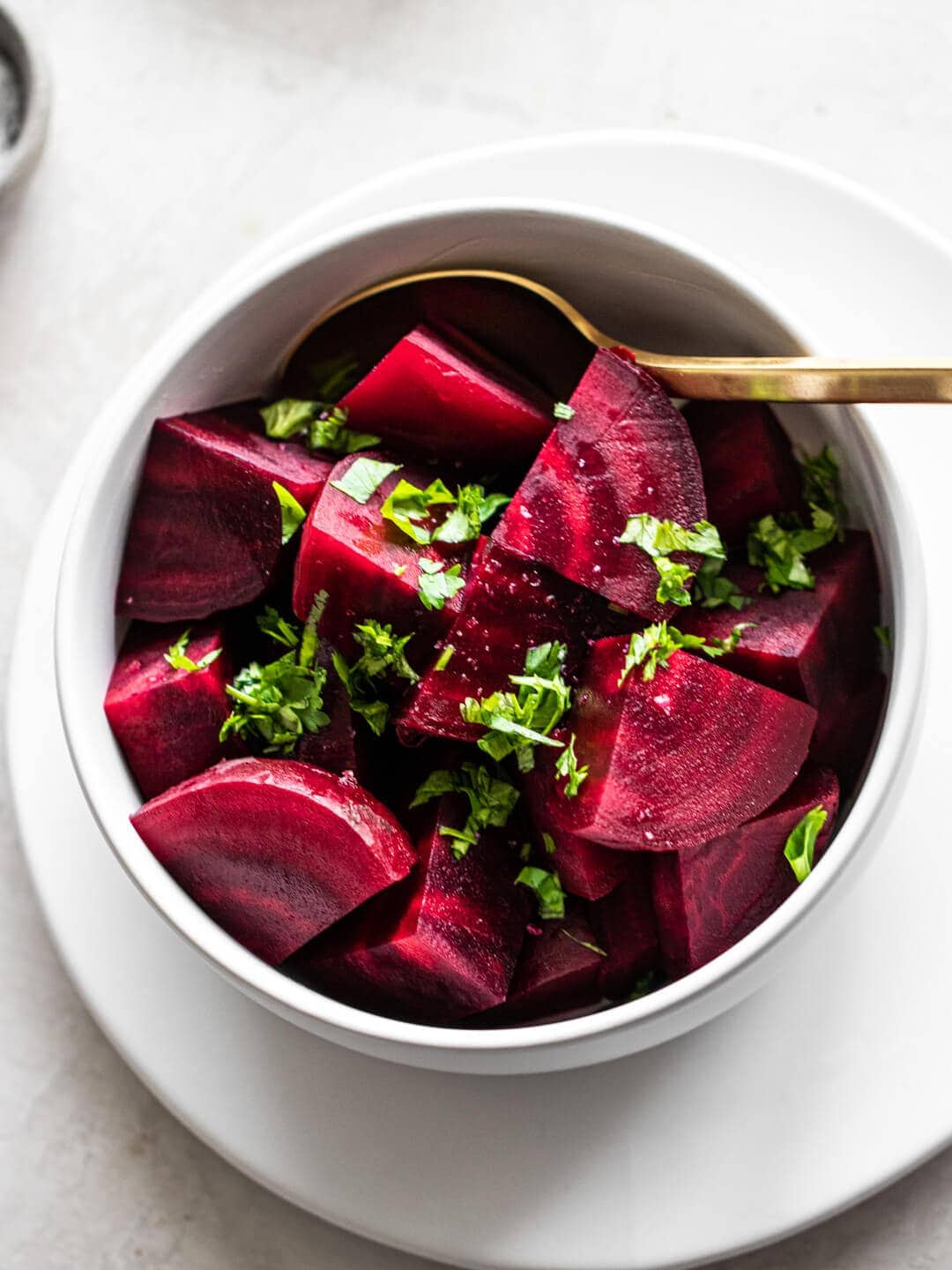 A bowl of beets cooked in the Instant Pot, topped with fresh parsley.