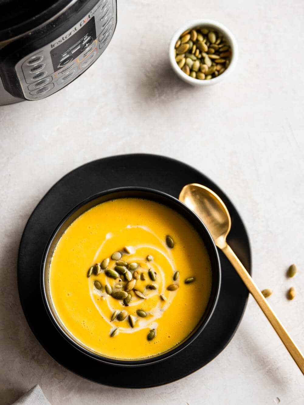 Bowl of butternut squash soup next to the Instant Pot.