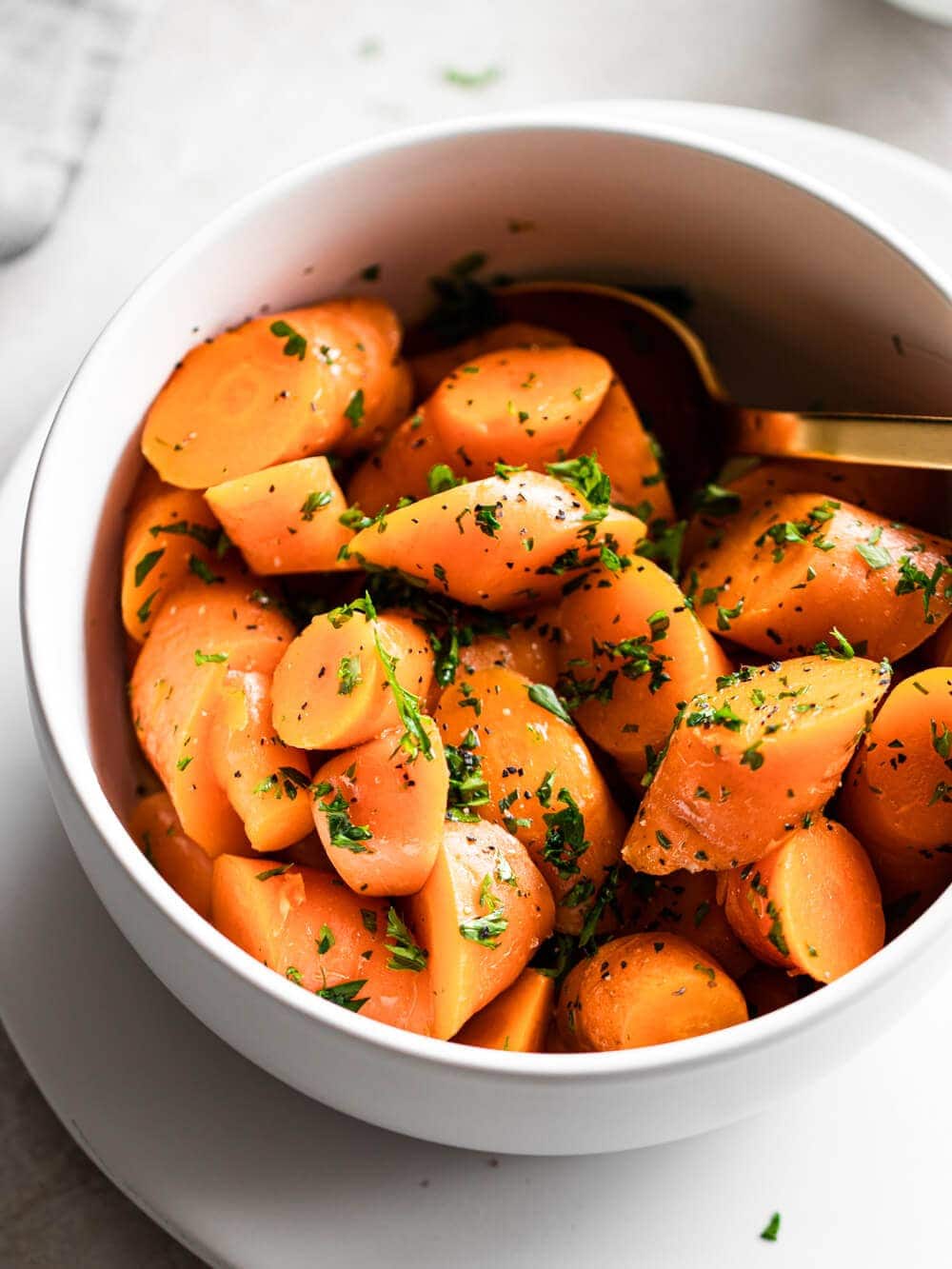A bowl of carrots topped with fresh herbs.