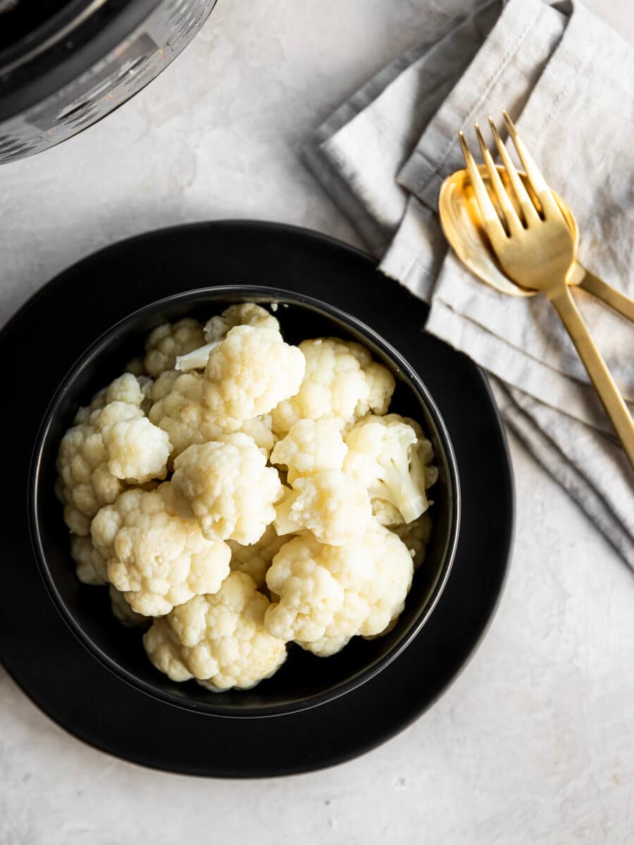A bowl of cooked cauliflower without any fresh herbs. 