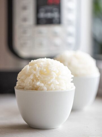 Two bowls of jasmine rice with the Instant Pot in the background.