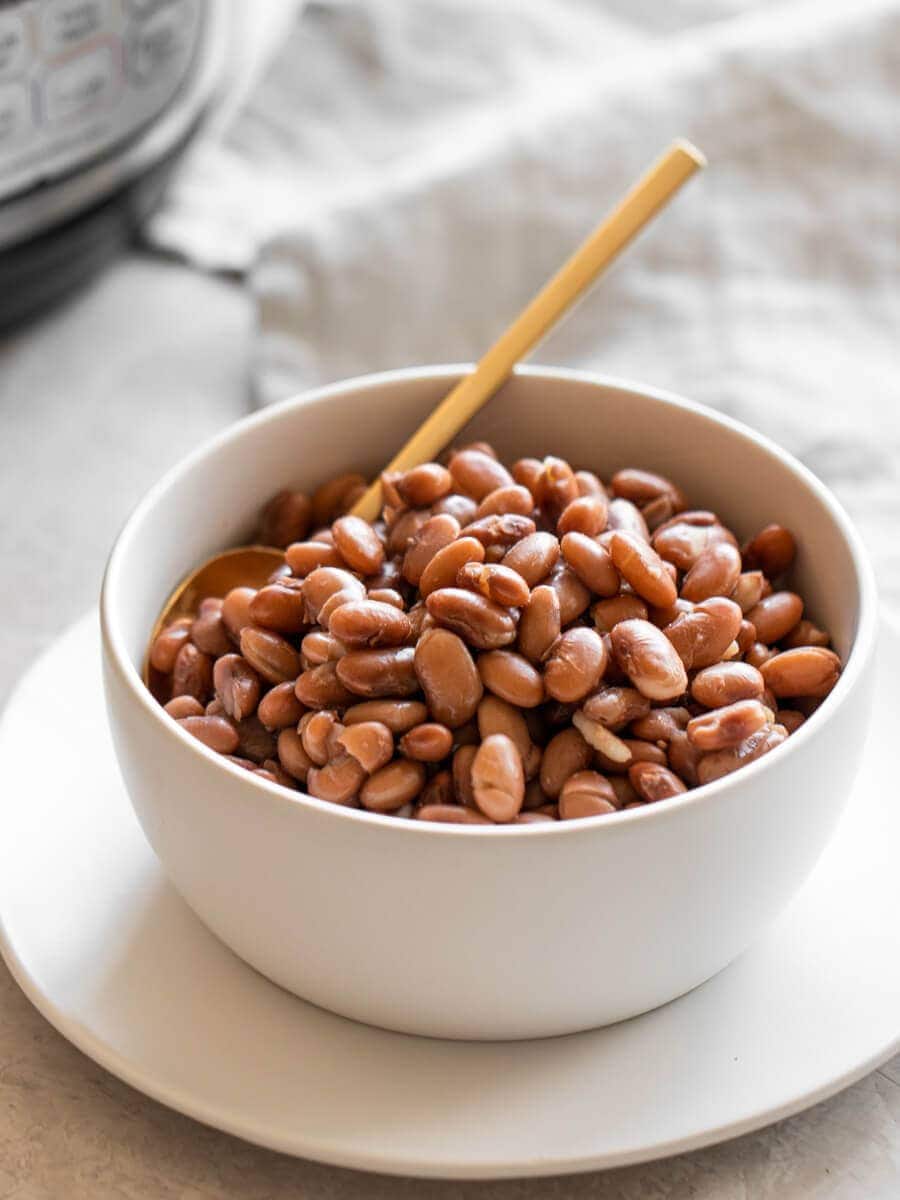 A bowl of pinto beans sitting in front of an Instant Pot