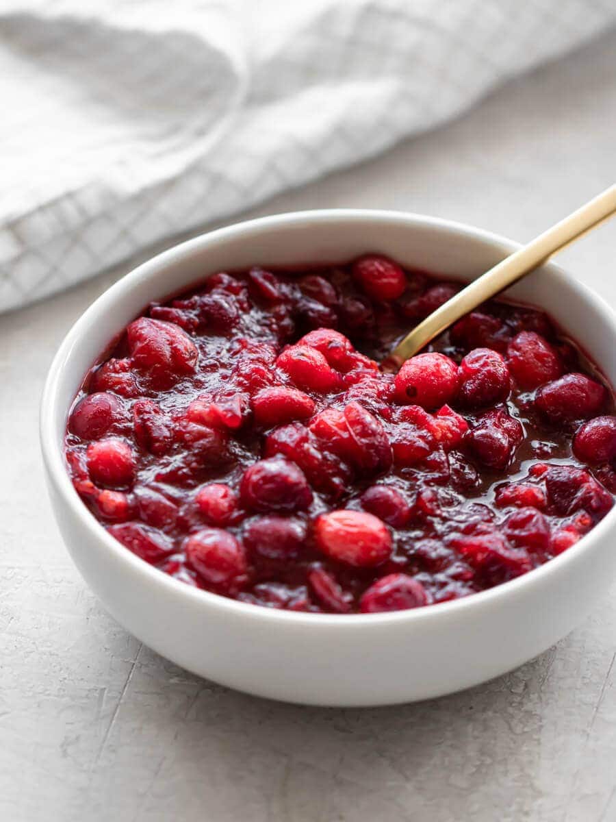 Bowl with cranberry sauce with a cloth in the background.