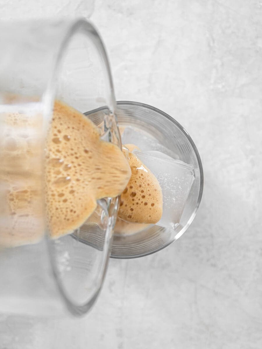 Drink being poured into cup of ice from a blender.