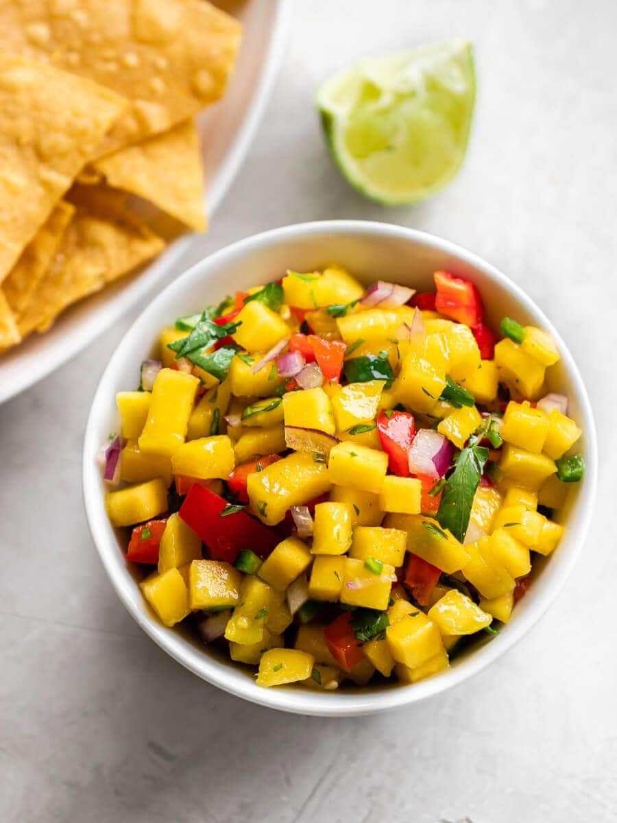 Bowl of mango salsa and chips on the side.