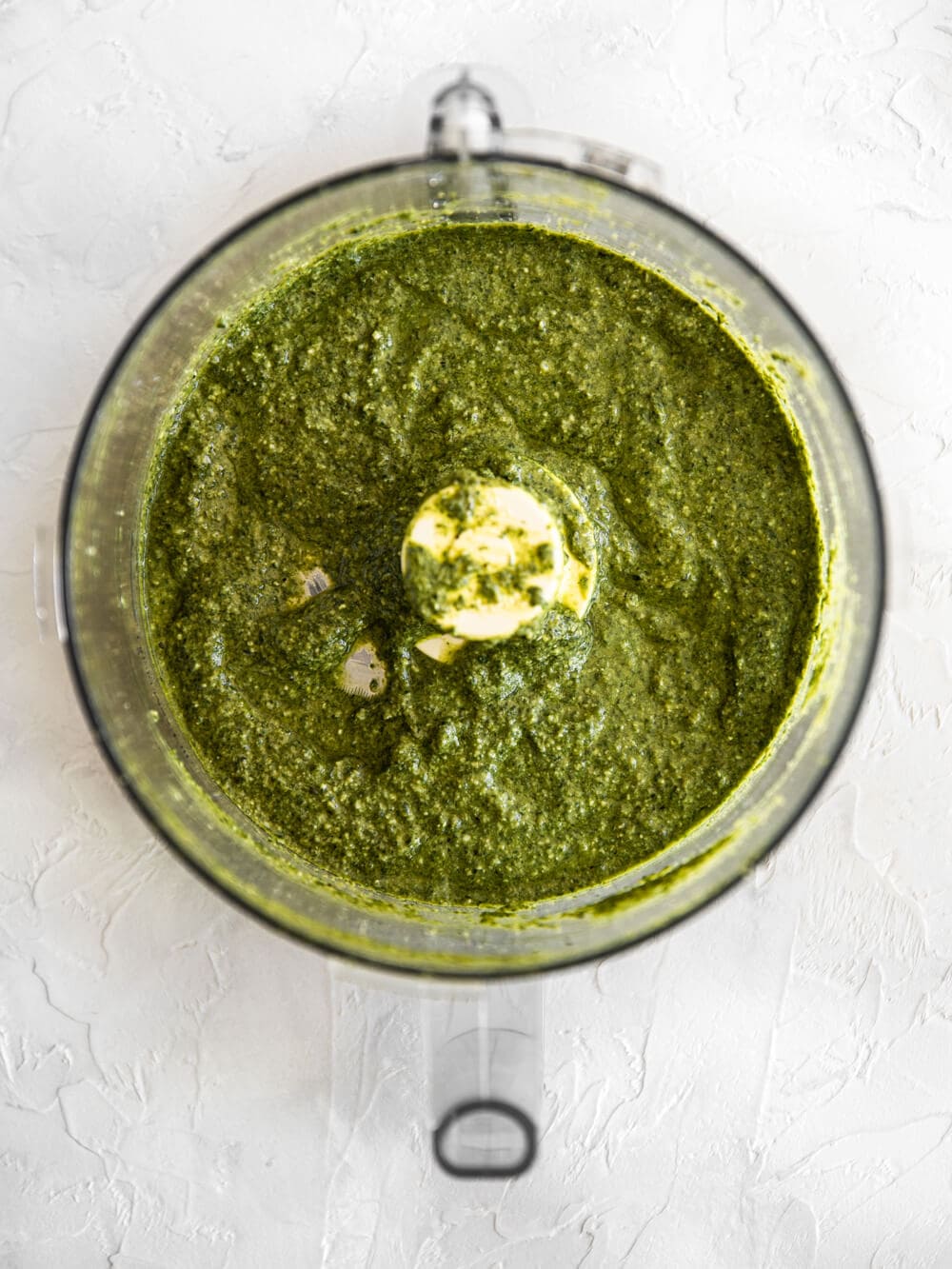 Food processor filled with basil pesto.