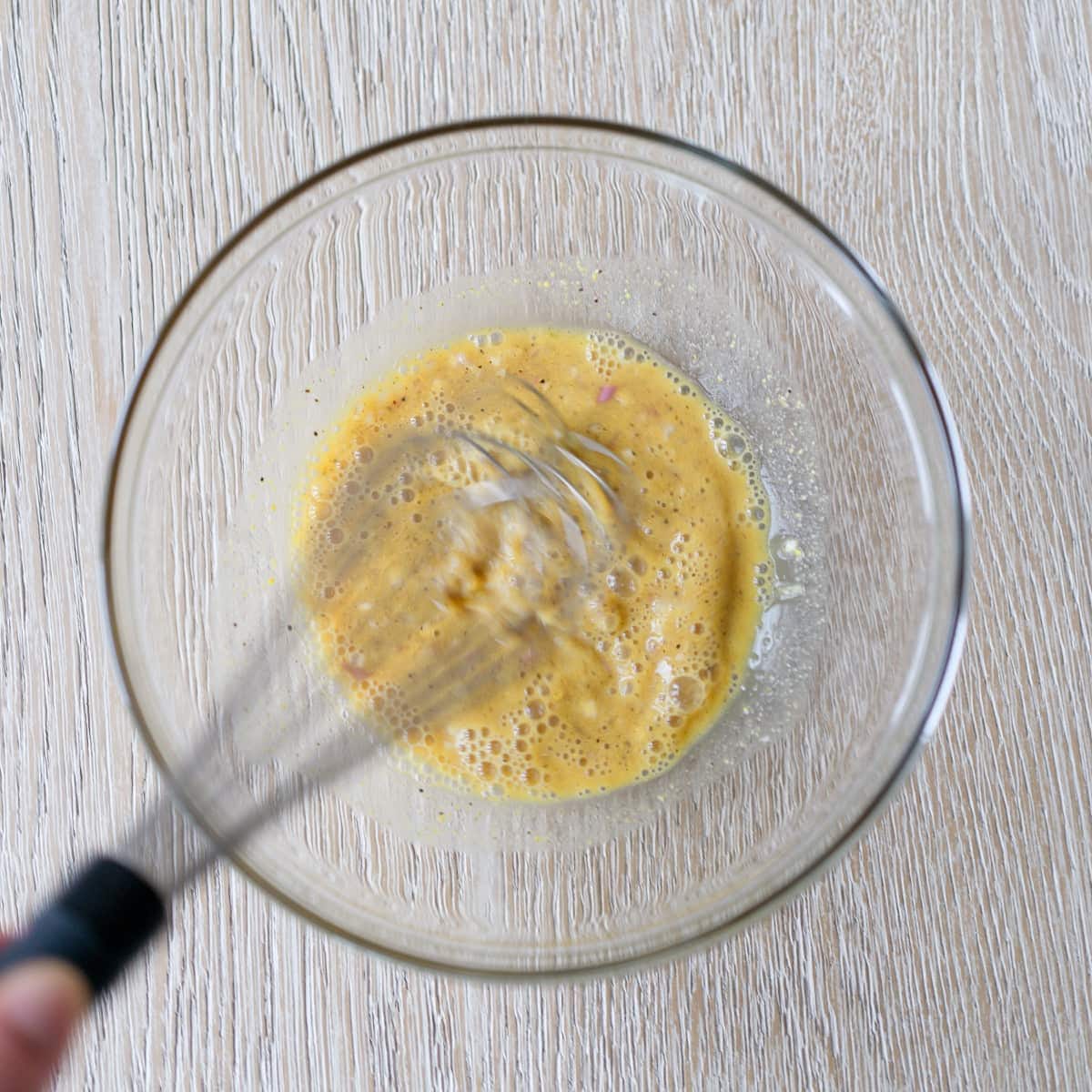 Whisking ingredients for apple cider vinaigrette.