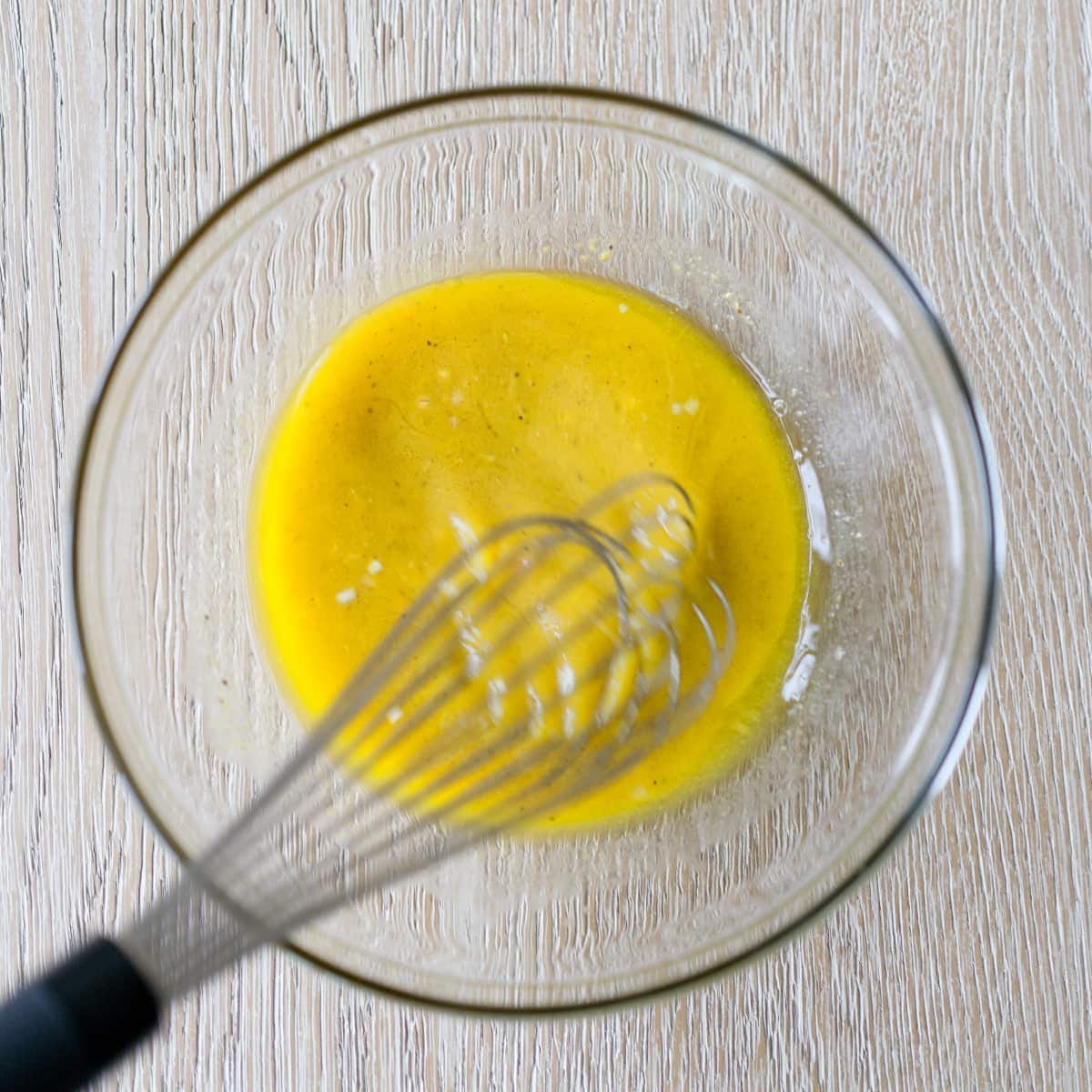 Whisking ingredients for apple cider vinegar dressing.