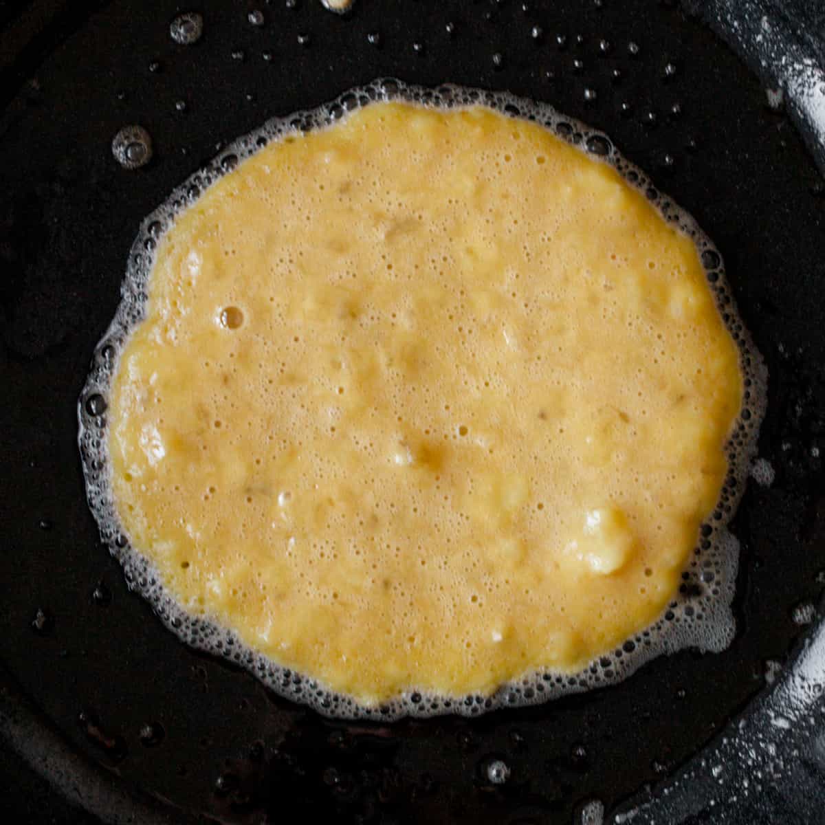 Banana pancake cooking on skillet.
