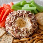 Close-up of cheese ball surrounded by vegetables and crackers.