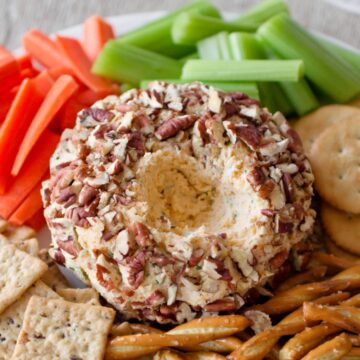 Close-up of cheese ball surrounded by vegetables and crackers.