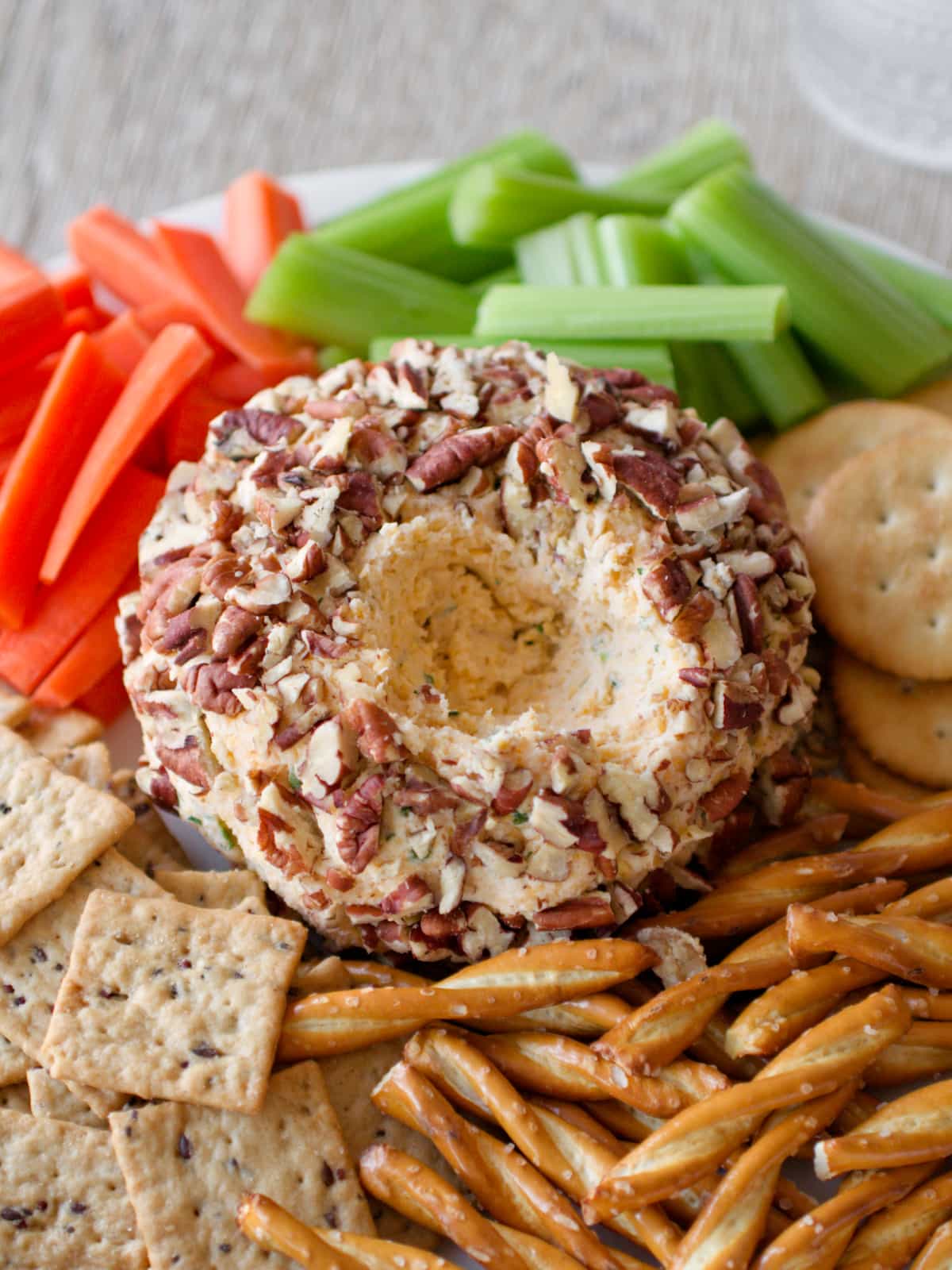 Close-up of cheese ball surrounded by vegetables and crackers.