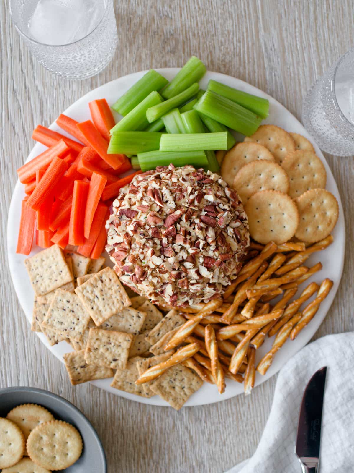 Cheese ball platter with vegetables and crackers.