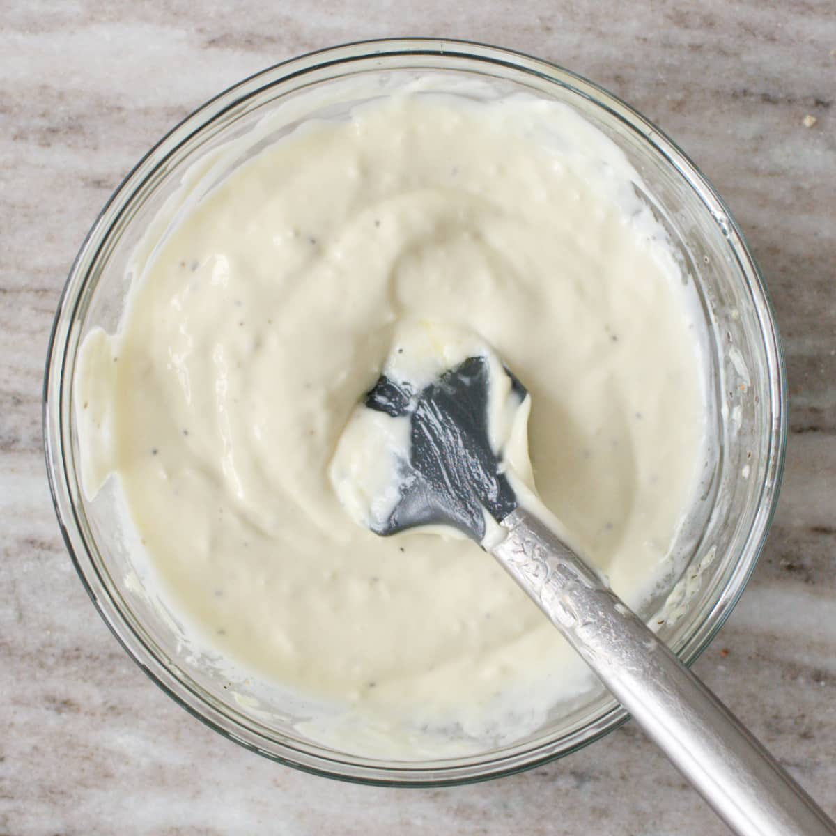 Bowl of garlic mayonnaise and spatula.