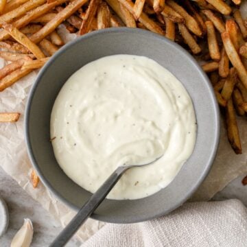 Bowl of garlic mayonnaise and fries.