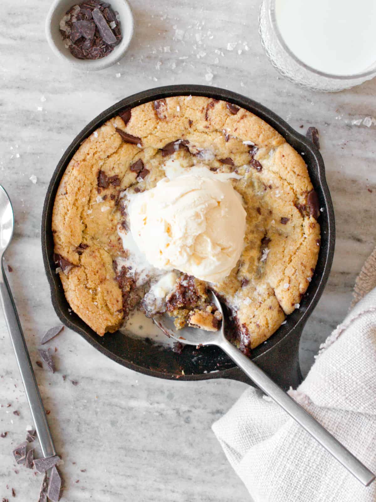 Mini skillet cookie with a scoop of ice cream and spoon.