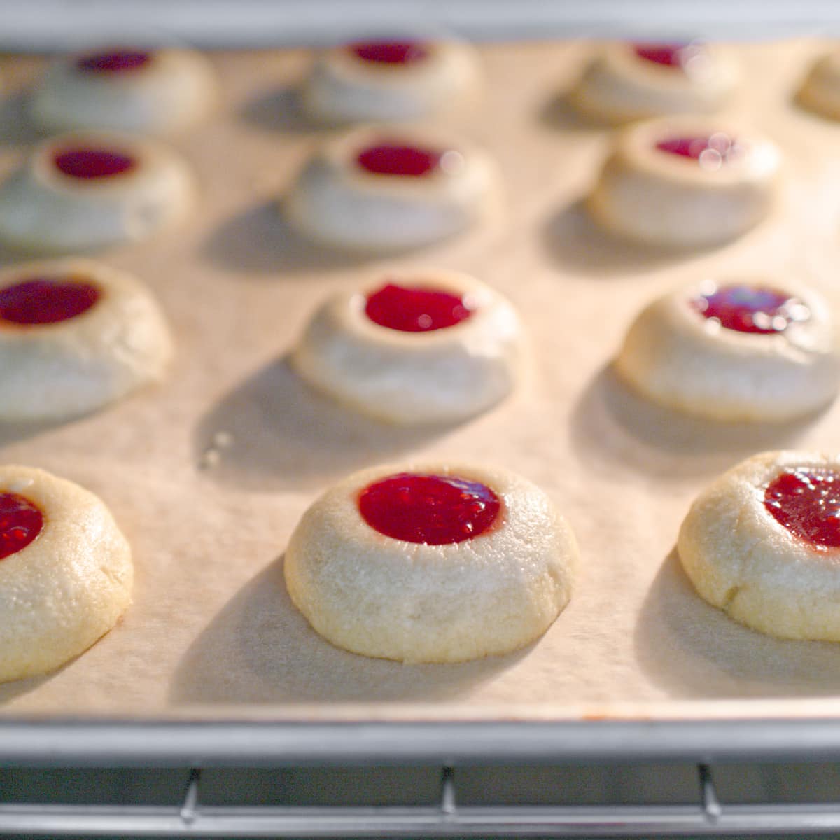 Raspberry thumbprint cookies baking in oven.