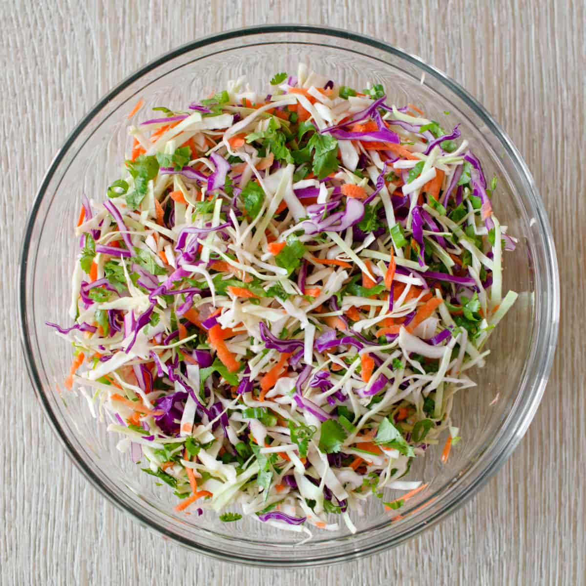 Taco slaw ingredients mixed in large bowl.
