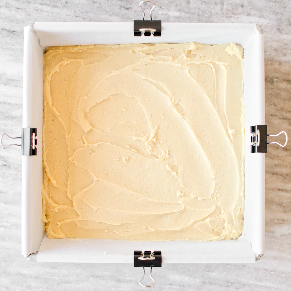 Cookie dough spread in baking pan.