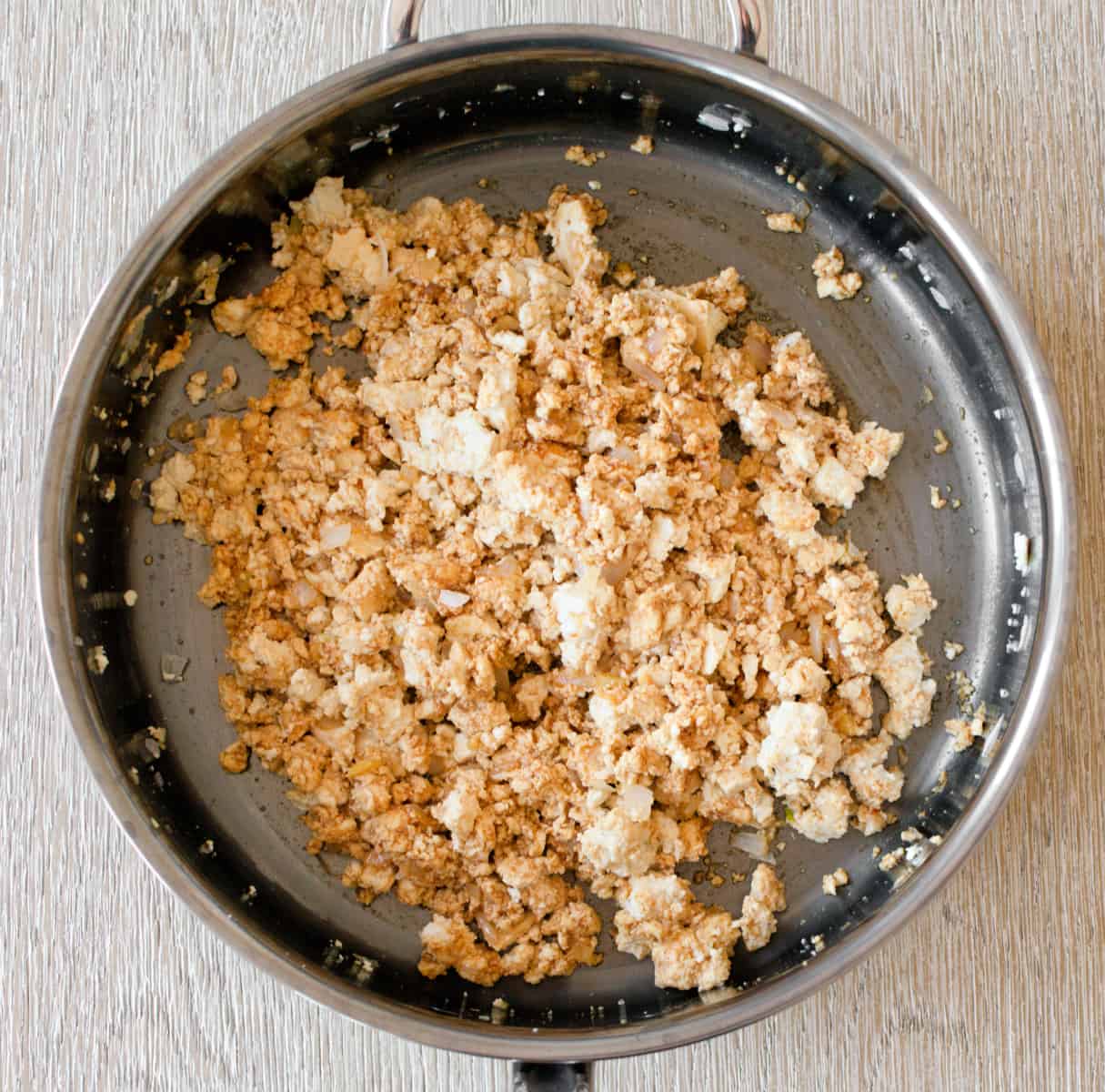 Sauce added to tofu and aromatics mixture in pan.