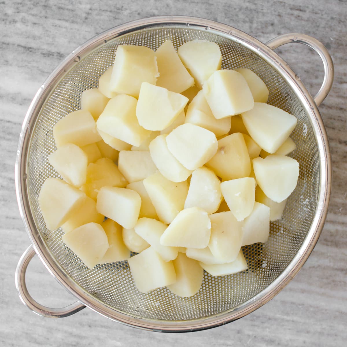 Boiled potatoes in a strainer.